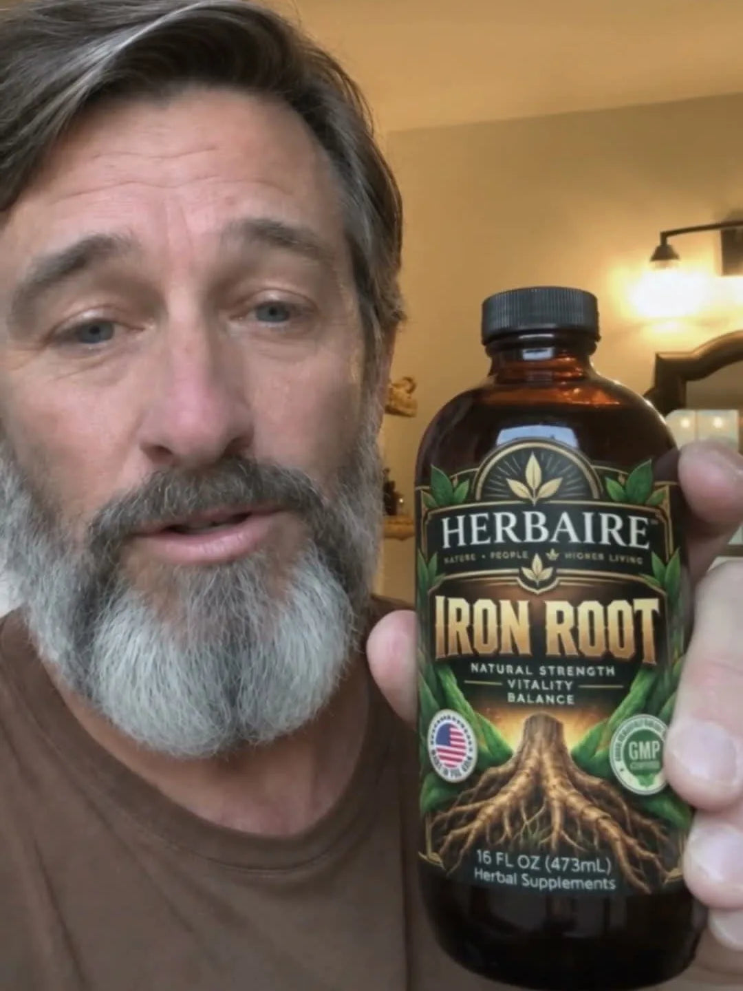 A man holding a bottle of Iron Root