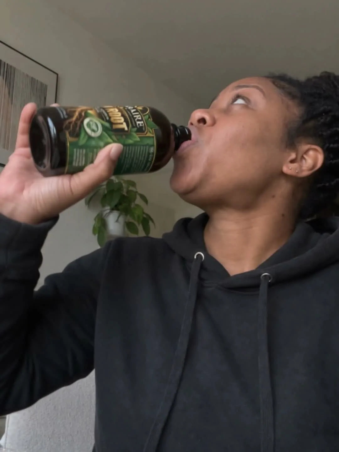 A woman taking a shot of Iron Root