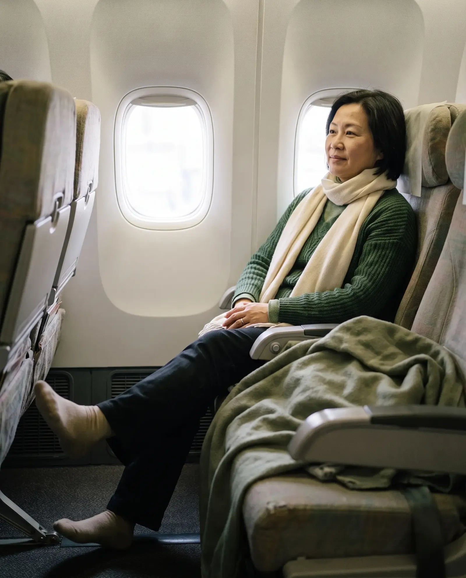 A traveler stretching her legs in a window seat